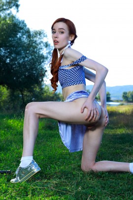 Рыжеволосая худая девка задирает юбку на природе